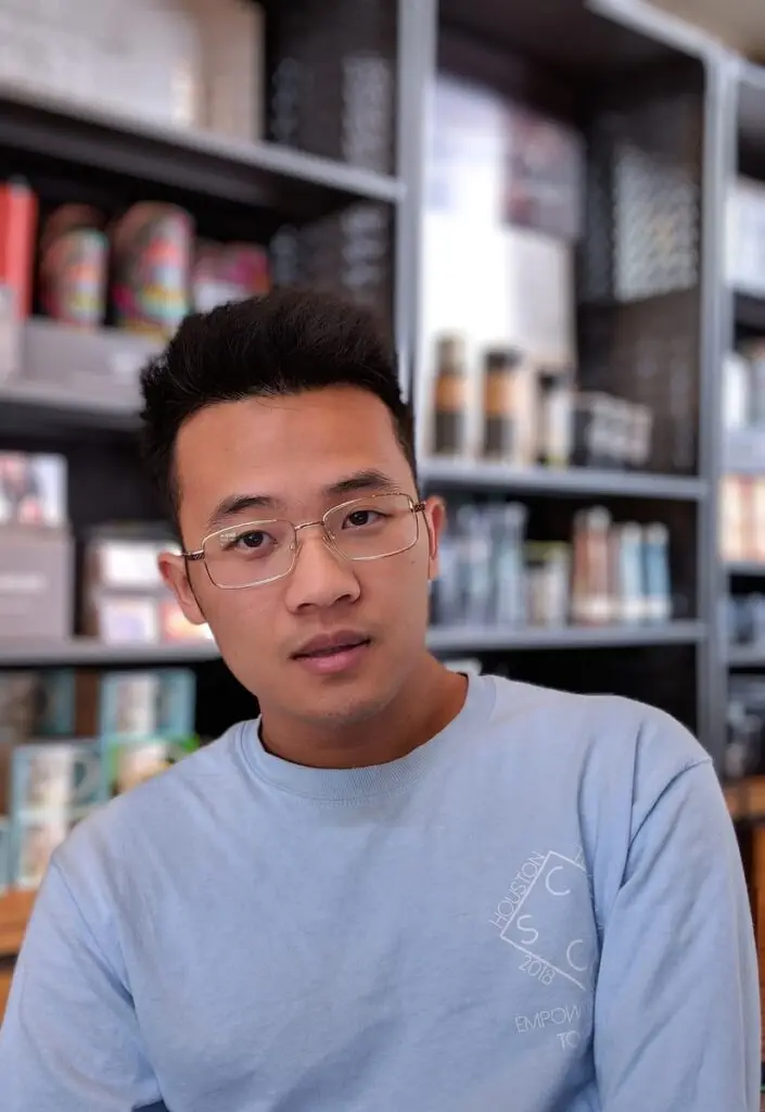 man wearing eyeglasses and blue shirt inside coffee shop